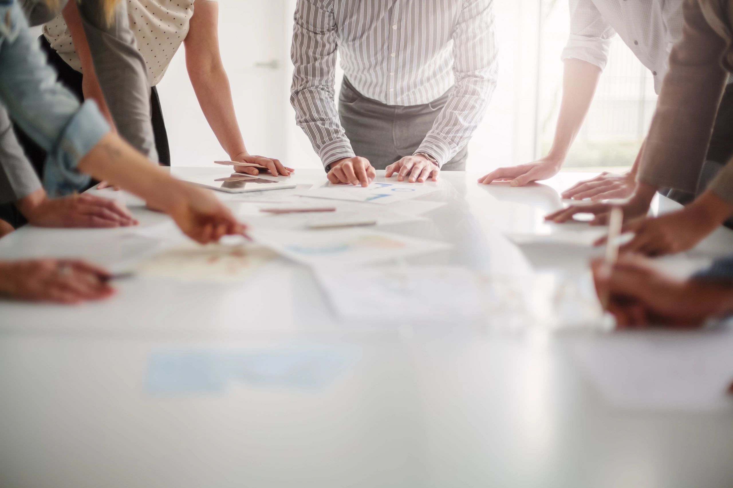Team collaborating over planning documents and workflow notes on a table